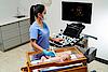Imaginea prezintă un medic ce efectuează un examen ecografic hepatic al unui copil.