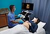 Imaginea prezintă un medic ce efectuează un examen ecografic al unei femei însărcinate.