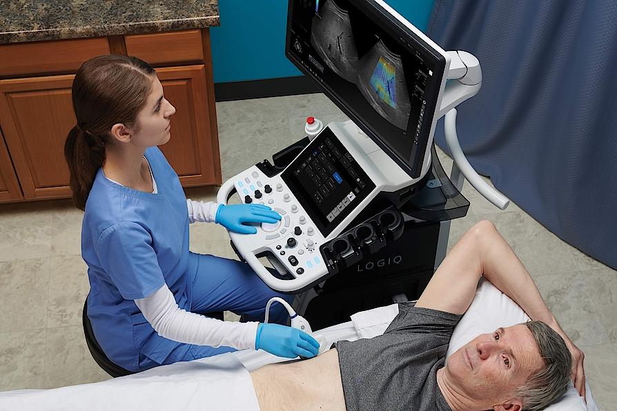 Na zdjęciu widać lekarza przeprowadzającego badanie ultrasonograficzne jamy brzusznej pacjenta.