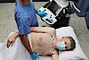 A képen egy orvos látható, aki szív-ultrahangvizsgálatot végez egy betegen.