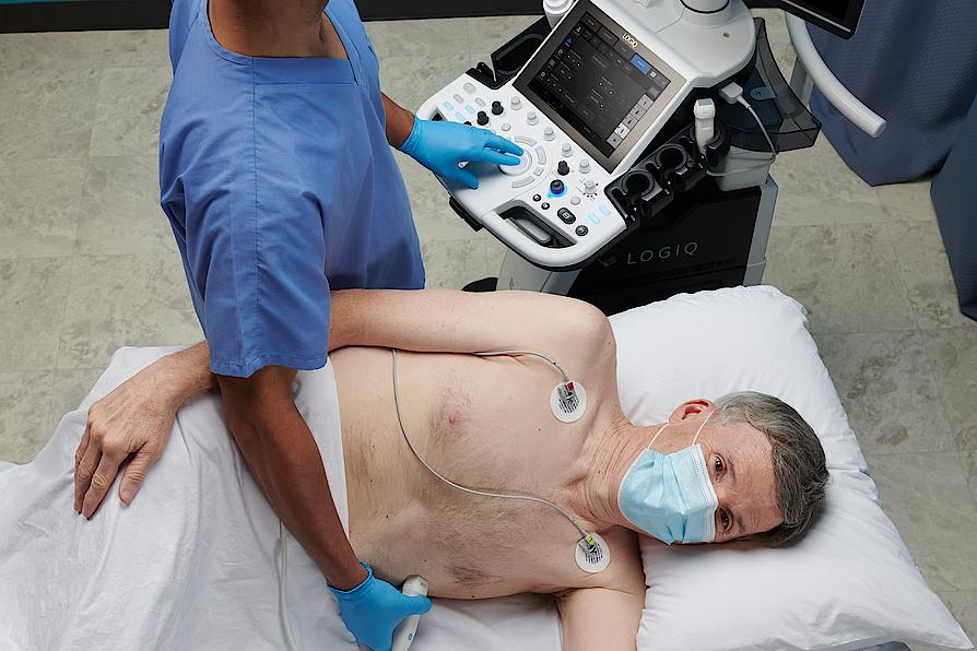 Obrázek znázorňuje lékaře provádějícího ultrazvukové vyšetření srdce u pacienta.