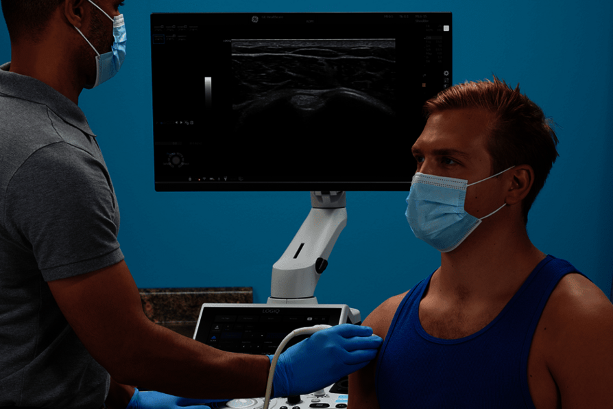 A képen egy orvos látható, aki mozgásszervi ultrahangvizsgálatot végez egy betegen.